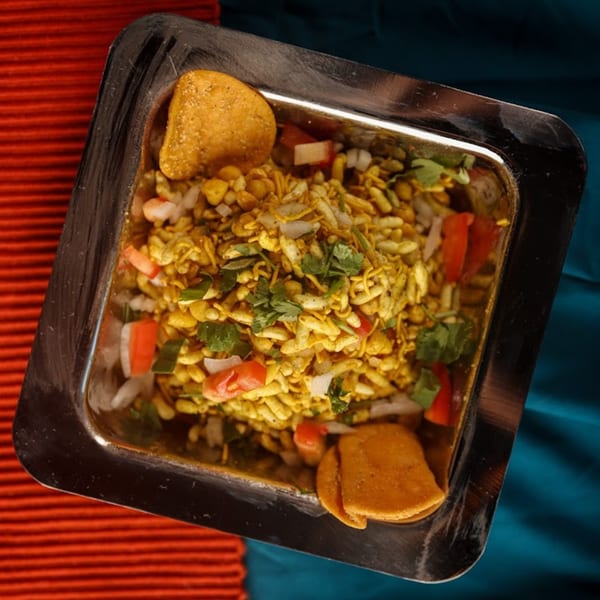 Overhead view of Chaska Indian Restaurant's Bhel Puri, a savory snack with puffed rice and vegetables.